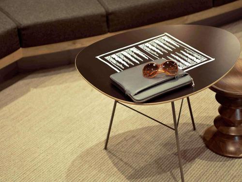 een kleine tafel met een bril erop bij ibis Issy les Moulineaux "Val de Seine" in Issy-les-Moulineaux