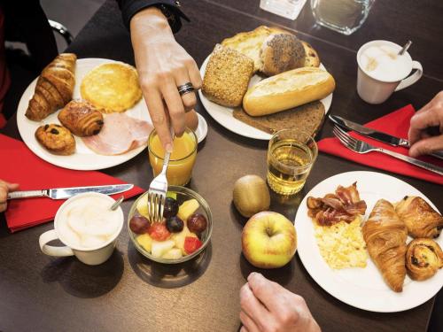 a table with plates of breakfast food on it at ibis Leiden Centre in Leiden