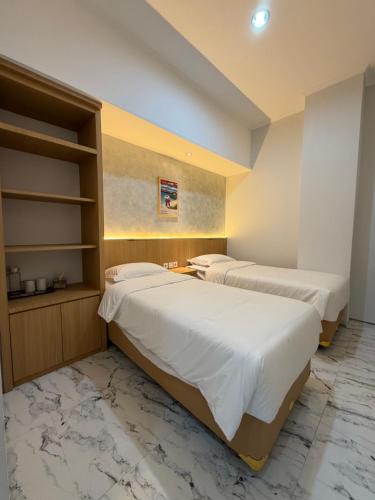 2 letti in una camera con pavimenti in marmo di Aurora House Surabaya a Wijung