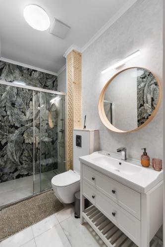 a bathroom with a sink and a toilet and a mirror at Willa Monte in Zakopane