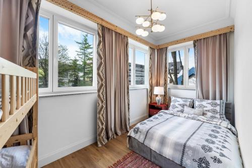 a bedroom with a bed and windows at Willa Monte in Zakopane