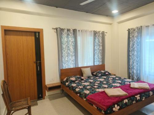 a bedroom with a bed and a door and windows at Cleanslate homestay in Guwahati