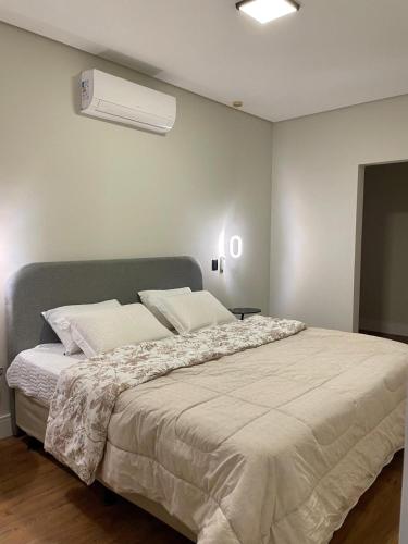 a bedroom with a large bed and a air conditioner at Maison Joia dos Vinhedos in Vinhedo