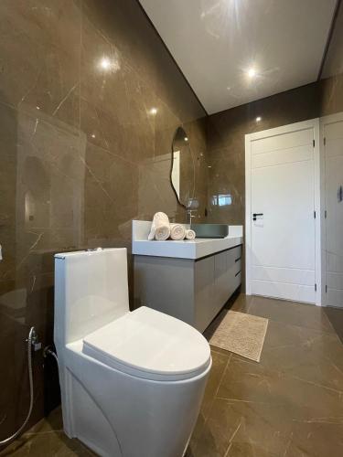 a bathroom with a white toilet and a sink at Maison Joia dos Vinhedos in Vinhedo