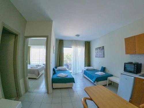 een hotelkamer met twee bedden en een keuken bij Ivory Serenity in Theologos