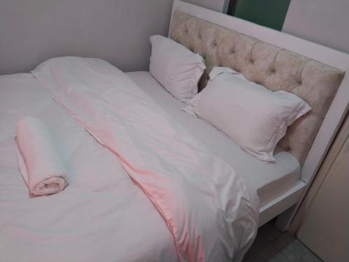 a bed with white sheets and pillows on it at Staycation with Shicks in Nairobi
