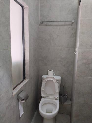 a small bathroom with a toilet and a window at Staycation with Shicks in Nairobi