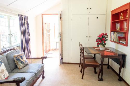 a living room with a table and a couch at Douglas Drift Cottages in Underberg