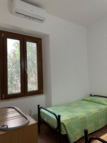una camera da letto con un letto e una finestra di Gli ulivi -Appartamento al centro a Cala Gonone