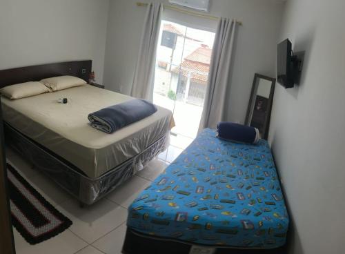a bedroom with a bed and a bench in front of a window at Alugo kitnet com café da manhã in Aparecida