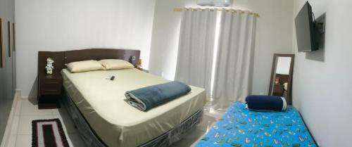 a bedroom with a bed and a blue stool at Alugo kitnet com café da manhã in Aparecida
