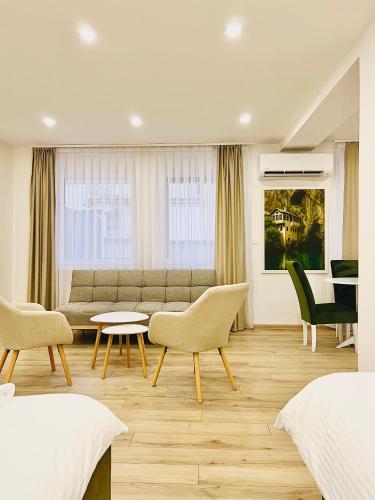 a bedroom with a couch and a table and chairs at AMARIS Suites Sarajevo in Sarajevo