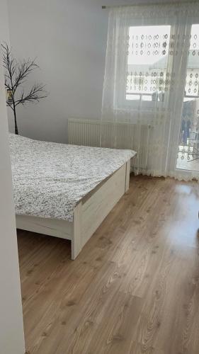 a bedroom with a bed and a wooden floor at Apartament in Suceava