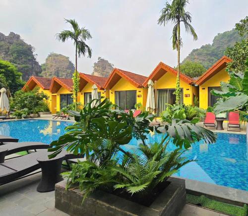 un resort con piscina e palme di For You Ninh Binh Boutique a Ninh Binh