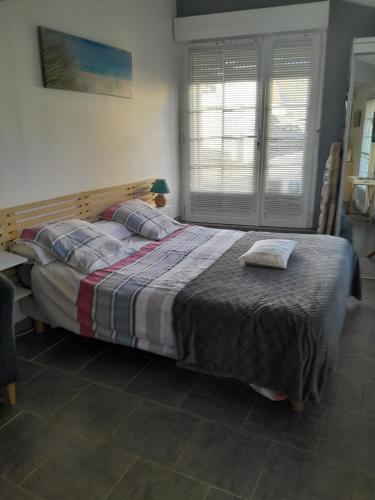 een slaapkamer met een groot bed in een kamer bij Les oyats in Le Crotoy