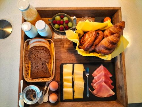 a tray of food with bread and pastries and fruit at De oude walnoot in Sint Pancras