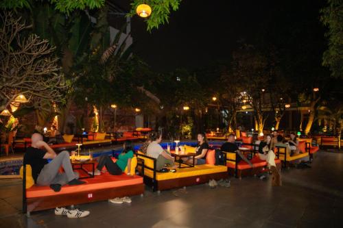 a group of people sitting at tables in a restaurant at night at Wow Tam Coc Homestay in Vũ Lâm