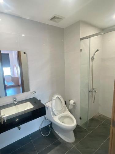 a bathroom with a toilet and a sink and a shower at Happy One Central Hottel in Trạm Chánh An