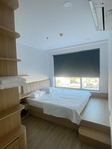 a bedroom with a bed and a large window at Happy One Central Hottel in Trạm Chánh An