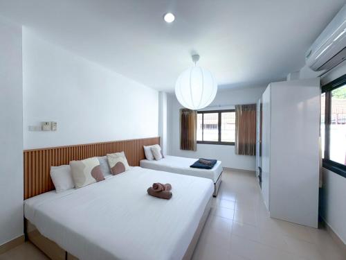 a bedroom with two beds and a large window at Home to my heart mare pool villa in Jomtien Beach