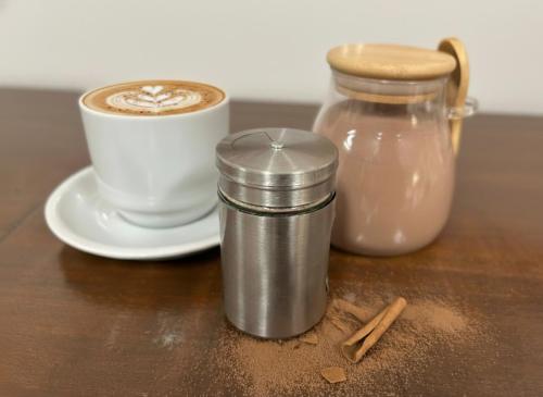 een kop koffie en een kan melk op een tafel bij SUITES - Românticas na natureza para adultos in Itapecerica da Serra