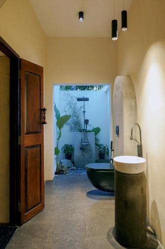 a bathroom with a bath tub and a sink at Kash Beach Villa, Varkala - Steps from Odayam Beach in Varkala