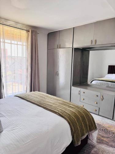 a bedroom with a large bed and a large mirror at Bleu Haven in Kitale
