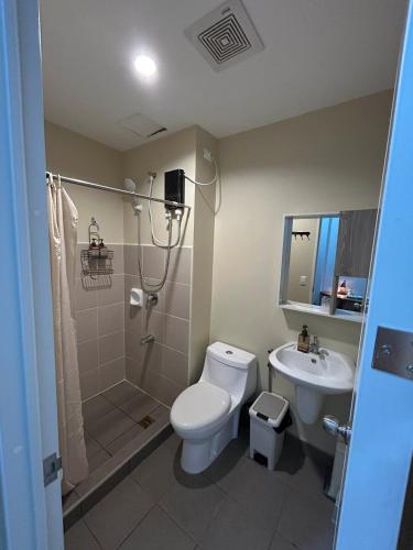 a bathroom with a toilet and a shower and a sink at Avida Tower 1, Unit 2003 - Chi's Place in Cagayan de Oro