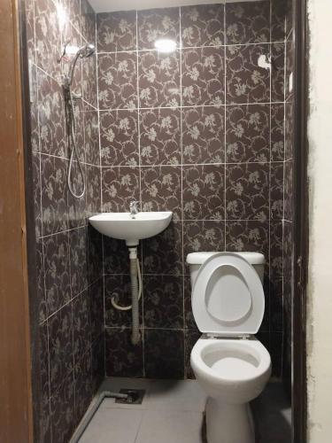 a bathroom with a toilet and a sink at SHAMA HoTEL in Kuala Lumpur