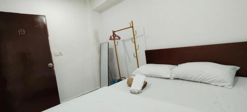 a bedroom with a bed with white sheets and a lamp at SHAMA HoTEL in Kuala Lumpur