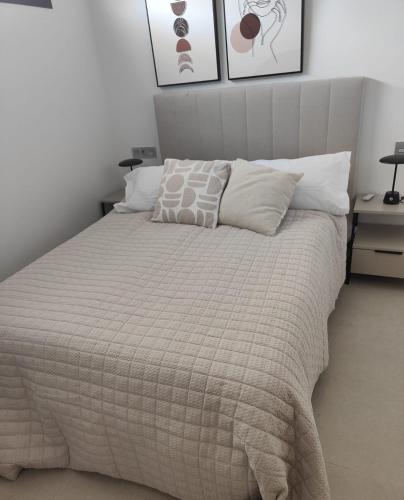 a bedroom with a bed with a blanket and pillows at La Mosa Sol in San Javier
