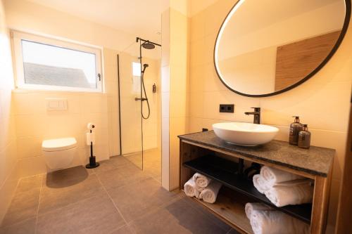 een badkamer met een wastafel en een spiegel bij dein Dahoam Boutique Appartements in Gröbming