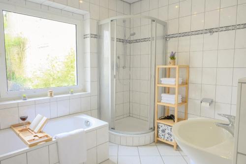 a bathroom with a tub and a shower and a sink at Hofgut Eveshausen - Dreiseitenhof - Spielscheune - Landidylle - Hofleben in Dommershausen