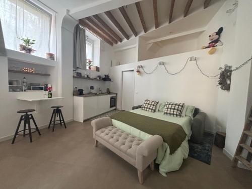 a bedroom with a bed and a couch and a kitchen at Cà du Local in Arenzano