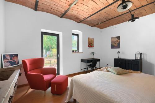 a bedroom with a bed and a chair and a desk at Stodola Rybojady in Rybojady