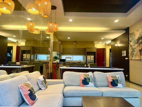 a living room with two white couches and a kitchen at Home to my heart pool villa in Jomtien Beach