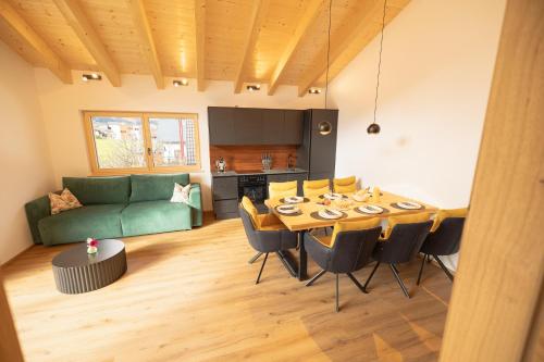een woonkamer met een tafel en een groene bank bij dein Dahoam Boutique Appartements in Gröbming