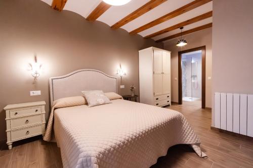 a bedroom with a white bed and a wooden floor at Encanto de Valderrobres in Valderrobres