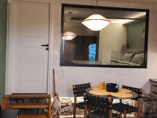 een eetkamer met een tafel en een spiegel bij Φεγγαρόπετρα -ΠΑΝΣΕΛΗΝΟΣ in Kalívia