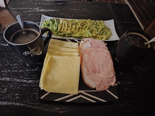 a plate of cheese and meat and vegetables with a cup of coffee at Santo Bucalemu Lodge in San Antonio