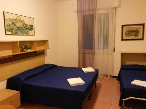 Cette chambre comprend un lit bleu et deux chaises. dans l'établissement Hotel Bel Sit, à Rapallo