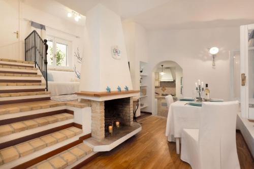 un soggiorno bianco con camino e tavolo di Villasimius - Villa Sofia a San Stèfano