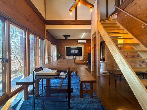 a room with a table and a staircase in a house at The Woods Villa Alps-Azumino in Azumino