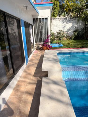 a swimming pool in a yard with a house at Casa en Cuernavaca Morelos in Cuernavaca