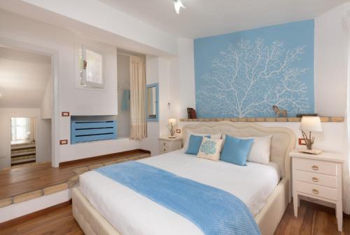 una camera da letto con un letto con una parete blu di Villasimius - Villa Sofia a San Stèfano