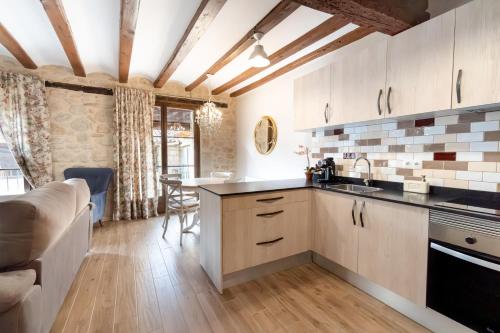 een keuken met houten kasten en een tafel in een kamer bij Encanto de Valderrobres in Valderrobres