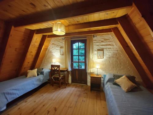 a attic room with two beds and a table at Welpen Chapa in Mar del Plata