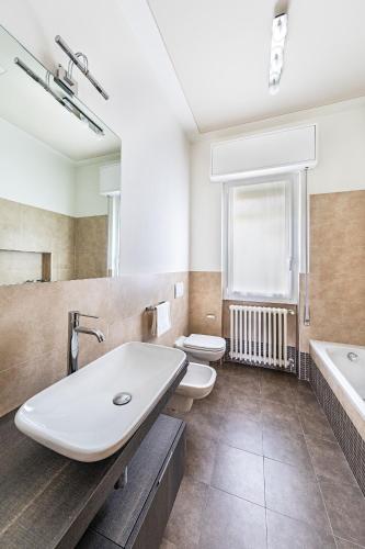 a bathroom with two toilets and a sink and a tub at Villa Elisa by Whale Homes in Padenghe sul Garda
