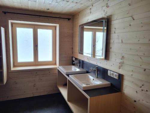 a bathroom with two sinks and two windows at Gästehaus Bischof in Damuls