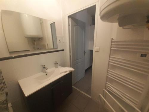 a white bathroom with a sink and a mirror at Elise en plein coeur de la ville in Saint-Étienne